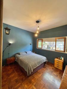 1 dormitorio con cama y pared azul en El PH de Chacarita en Buenos Aires