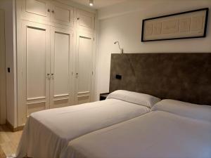 a bedroom with two beds and white cabinets at Apartamentos Zenit Mar in Noja +127 photos