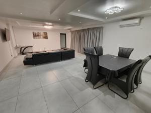 a conference room with a table and black chairs at In Town Vaal in Vereeniging