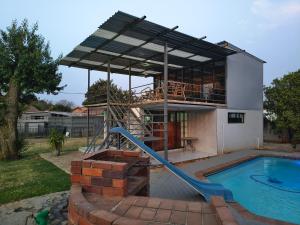 a house with a slide next to a swimming pool at In Town Vaal in Vereeniging