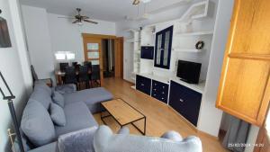 een woonkamer met blauwe banken en een televisie bij Dúplex San Lorenzo 2 PARKING GRATUITOS in Jaén
