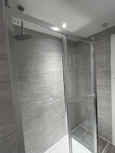 a shower with a glass door in a bathroom at New 2BED Kay Road SW9 London in London