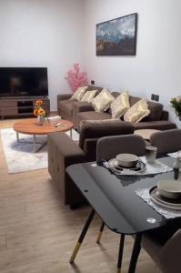 شاليه فراشة في الأحساء: غرفة معيشة مع كنب وطاولة وتلفزيون