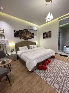 1 dormitorio con 1 cama grande con globos rojos en el suelo en شاليه فراشة, en Al-Hasa