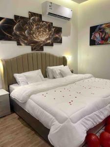 Un dormitorio con una cama con corazones rojos. en شاليه فراشة en Al Ahsa
