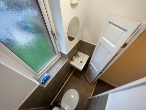 Cosy 4-Bed House in Manchester في مانشستر: حمام صغير مع مرحاض ومغسلة
