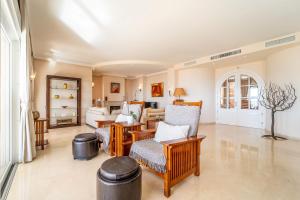 - un salon avec des chaises et un canapé dans l'établissement Beachside villa with panoramic sea views, à Benalmádena