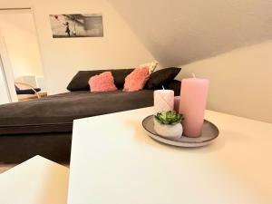 a living room with a couch and two candles on a table at Ferienwohnung Wilhelm in Steyerberg