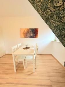 a white dining room with a white table and chairs at Ferienwohnung Wilhelm in Steyerberg