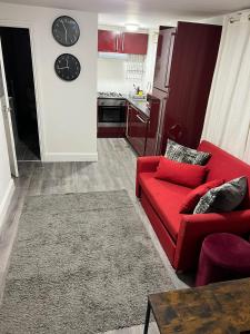 a living room with a red couch and a kitchen at New 2BED Kay Road SW9 London in London