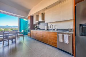 una cocina con armarios de madera y una mesa con sillas. en Luxurious Penthouse in Puerto Vallarta en Puerto Vallarta