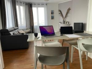 uma sala de estar com uma mesa com um computador portátil em Parfait pour visiter ou travailler près de Paris em Clamart