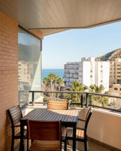 ein Balkon mit Tisch und Stühlen und Blick auf das Meer in der Unterkunft Beach Albir in Albir