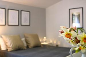 uma sala de estar com um sofá e um vaso de flores em Giglio di Mare em Ascea