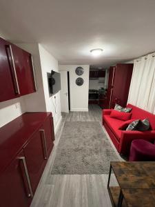 a living room with a red couch and a kitchen at New 2BED Kay Road SW9 London in London