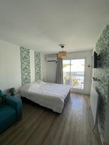 een slaapkamer met een bed en een blauwe bank bij Studio kassav in Saint-François +37 foto's