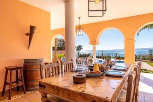 a dining room with a wooden table and chairs at Beachside villa with panoramic sea views in Benalmádena