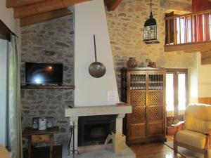Una sala de estar con chimenea y televisión. en Casa Rural la Esperilla de Gredos, en Barajas de Gredos