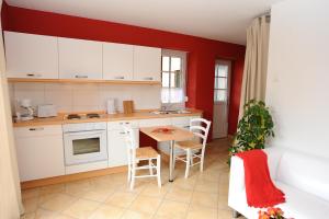 ブルクにあるKASTANIENHOFの白いキャビネットとテーブルと椅子のあるキッチン