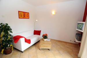 - un salon avec un canapé blanc et des oreillers rouges dans l'établissement KASTANIENHOF, à Burg