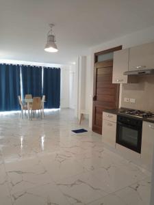 a kitchen with a stove and a table with chairs at Poppy Court in Marsaskala