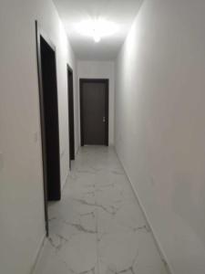 an empty hallway with white walls and a black door at Poppy Court in Marsaskala