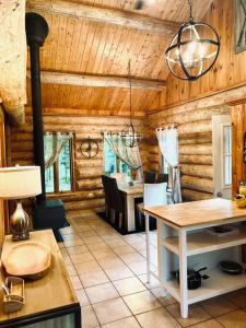een woonkamer met houten wanden en een eetkamer bij Chalets Terre De l’Orme with Spa tucked away in nature in Saint-Gabriel-De-Valcartier