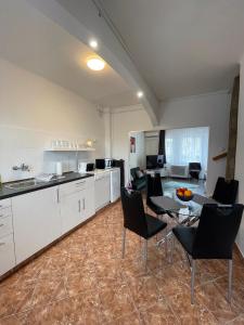 a kitchen and living room with a table and chairs at Vár-Lak Apartman in Balatonfůzfő