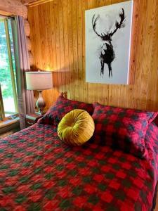 a bedroom with a bed with a deer on it at Chalets Terre De l’Orme with Spa tucked away in nature in Saint-Gabriel-De-Valcartier