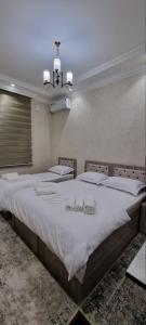 a bedroom with a large bed with white sheets at YASMIN in Samarkand