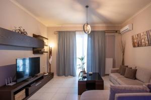 uma sala de estar com um sofá e uma televisão em Fivos apartment em Zakynthos