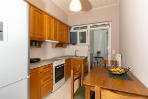 una cocina con una mesa de madera y un bol de fruta. en Fivos apartment, en Zakynthos