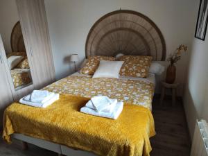 ein Schlafzimmer mit einem Bett mit Handtüchern darauf in der Unterkunft Appartement de Charme L'Isle-sur-la-Sorgue sur la Sorgues in LʼIsle-sur-la-Sorgue