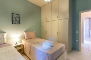 Fivos apartment في مدينة زاكينثوس: غرفة نوم بسريرين يوجد مناشف على السرير