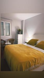 a bedroom with a large bed with a yellow blanket at Apartamento av.Galicia playa in Finisterre