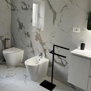 a white bathroom with a toilet and a sink at Villa Manzo-Pompei Vesuvius in Boscotrecase