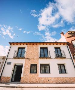 un edificio de ladrillo con ventanas y un cielo azul en Albergue Turístico LAbellaVILLA, en Rincón de Soto
