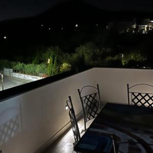 Boscotrecase的住宿－Villa Manzo relais -Pompei Vesuvius，夜间阳台上的桌椅
