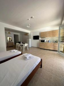 a large room with two beds and a kitchen at Azzurro in Paleros