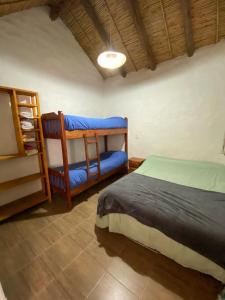 烏瑪瓦卡的住宿－Cabañitas EL REPOSO HUMAHUACA，一间卧室配有一张床和一张蓝色椅子