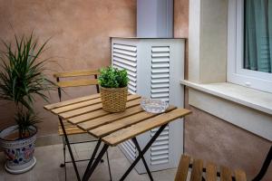 uma mesa de madeira com um vaso de plantas numa varanda em Elorino Chic&Relax em Rosolini