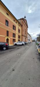 une rue vide avec des voitures garées à côté d'un bâtiment dans l'établissement Dimora del Castello - Comfort & Privacy, à Castel Maggiore