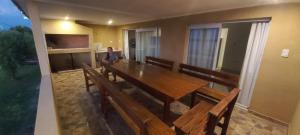 a woman sitting at a long wooden table with benches at Apart Santa Elena in Santa Elena
