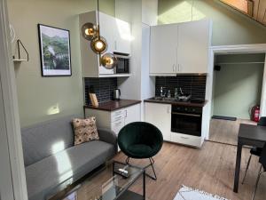 uma sala de estar com um sofá e uma cozinha em Cozy backyard apartment em Trondheim