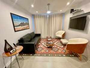 een woonkamer met een bank en een tafel bij Ipanema - Rainha Elizabeth - 2 Quartos in Rio de Janeiro