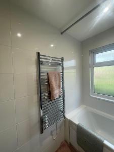 a bathroom with a bath tub and a window at Woodland bungalow, fantastic location in Uny Lelant