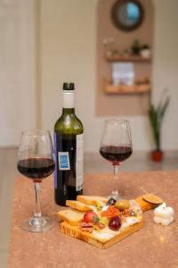 two glasses of wine next to a bottle of wine at Cozy Renting Hospedaje in Santa Rosa de Copán