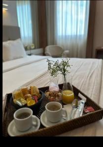 bandeja con alimentos para el desayuno y bebidas en una cama en QUARTO DUPLO - Suíte, en Linhares
