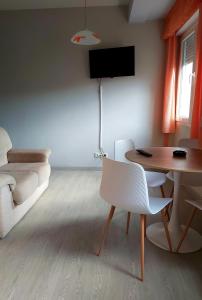 a living room with a table and white chairs at Novama in O Grove