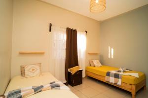 a bedroom with two beds and a window at Cozy Renting Hospedaje in Santa Rosa de Copán